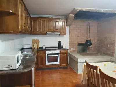 a kitchen with wooden cabinets and a stove top oven at Casa en zona rural in Cervo