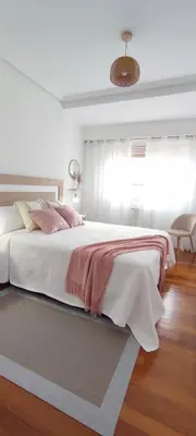 a white bedroom with a large bed with a blanket at Home Ourense Miño in Ourense