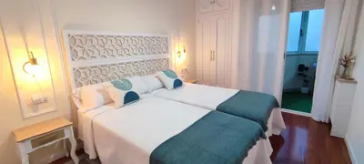 a bedroom with a large white bed with blue accents at Home Ourense Miño in Ourense