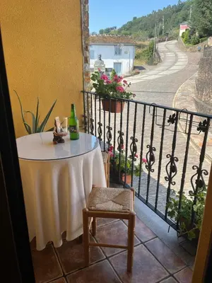 a table on a balcony with a view of a street at A Xanuca in Taramundi