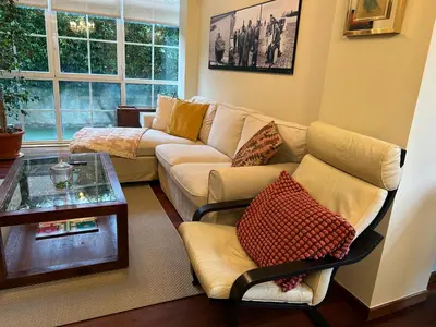 a living room with a couch and a table at Mar y Playa con Jardín in A Coruña