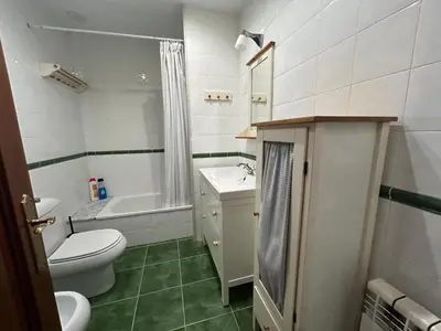 a bathroom with a toilet and a sink and a tub at Mar y Playa con Jardín in A Coruña