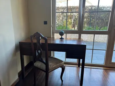 a wooden desk with a chair in front of a window at Mar y Playa con Jardín in A Coruña