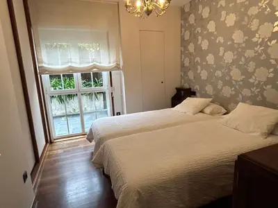 a bedroom with two beds and a window at Mar y Playa con Jardín in A Coruña