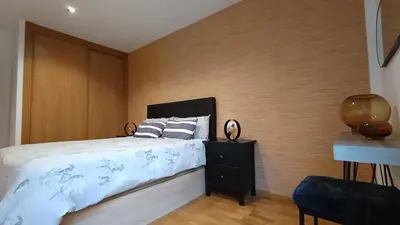 a bedroom with a bed and a wooden wall at Orballo in Ourense