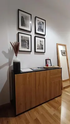 a wooden cabinet in a room with pictures on the wall at Orballo in Ourense