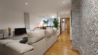 a living room with a white couch and a kitchen at Orballo in Ourense