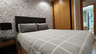 a bedroom with a bed and a desk and a wall at Orballo in Ourense