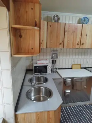 a small kitchen with a sink and a microwave at Acogedora casa a pie de playa in Cillero