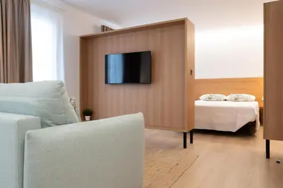 a room with a bed and a tv on a wall at Duerming Avenida 85 Burela VUT in Burela de Cabo