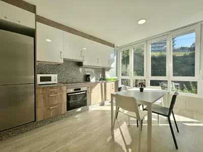 a kitchen with a table and a white table and chairs at Front Beach I in Sada