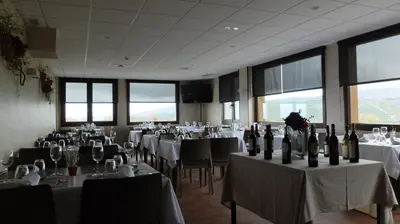 a room filled with tables and chairs with wine bottles at Hotel Albergue La Casa Del Peregrino in El Acebo de San Miguel