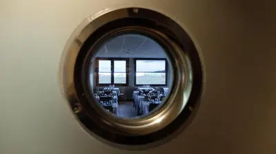 a round mirror reflecting a room with tables and chairs at Hotel Albergue La Casa Del Peregrino in El Acebo de San Miguel