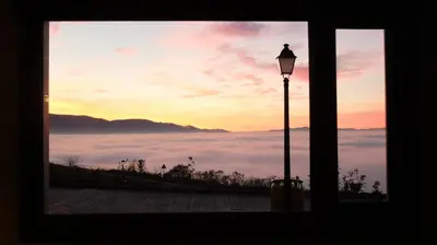 a window with a street light and a view of clouds at Hotel Albergue La Casa Del Peregrino in El Acebo de San Miguel
