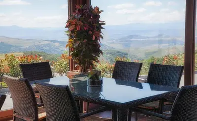 a table and chairs with a view of the mountains at Hotel Albergue La Casa Del Peregrino in El Acebo de San Miguel