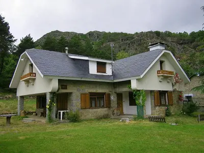 a large house with a roof on a green field at Casa Rural LOS MILLARES in Ribadelago