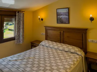 a bedroom with a bed and a window at Casa Rural LOS MILLARES in Ribadelago