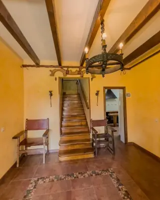 a hallway with stairs and a chandelier in a house at Casa Rural LOS MILLARES in Ribadelago
