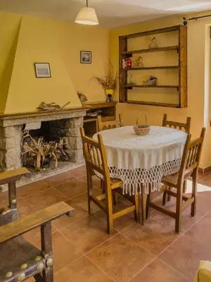 a dining room with a table and a fireplace at Casa Rural LOS MILLARES in Ribadelago