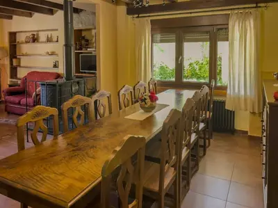 a dining room with a large wooden table and chairs at Casa Rural LOS MILLARES in Ribadelago