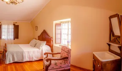 a bedroom with a bed and a sink and a mirror at Casa rural Catro do Lugarexo in Villarmayor