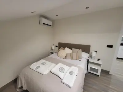 a bedroom with a bed with white sheets and towels at Calpurnia Abana in Ourense