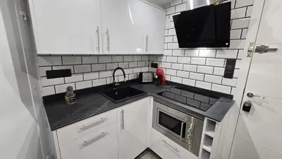 a small kitchen with a sink and a microwave at Calpurnia Abana in Ourense
