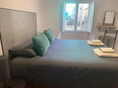 a large bed with blue sheets and pillows on it at A Casa do Sastre1 in Ribadavia