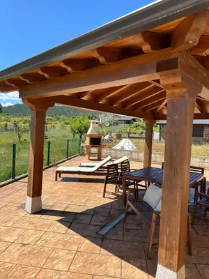 a wooden pavilion with a table and chairs on a patio at La casa de Canedo in Arganza