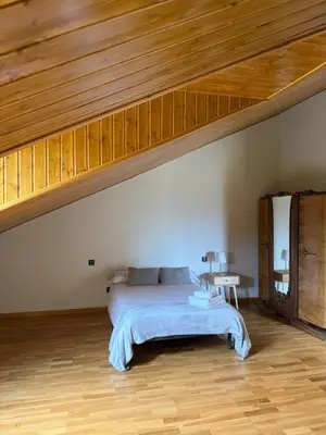 a bedroom with a bed and a wooden ceiling at La casa de Canedo in Arganza