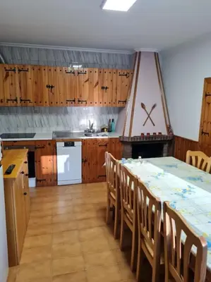 a kitchen with a table and some wooden cabinets at Casa San Miguel in Chantada