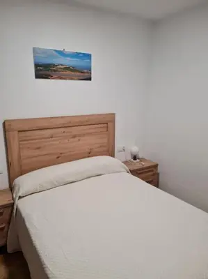 a bedroom with a bed and two nightstands and a picture at Casa San Miguel in Chantada