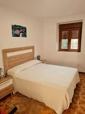 a bedroom with a white bed and a window at Casa San Miguel in Chantada