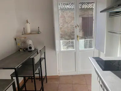 a kitchen with a table and chairs and a door at A Casa do Sastre 2 in Ribadavia
