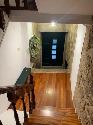 a hallway with a black door and a wooden floor at A Casa do Sastre 2 in Ribadavia