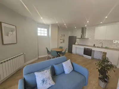 a living room with a blue couch and a kitchen at Lugo Apartamento nuevo en centro de la ciudad in Lugo