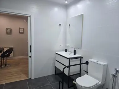 a bathroom with a toilet and a sink and a mirror at Lugo Apartamento nuevo en centro de la ciudad in Lugo