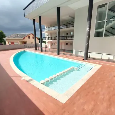 a large swimming pool in front of a building at Apartamento con piscina in Barreiros
