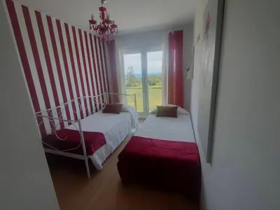 a bedroom with two beds and a window at Apartamento con piscina in Barreiros