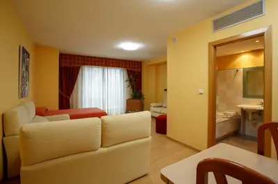 a living room with a couch and a bedroom at Hotel Restaurante Pontiñas in Lalín