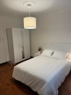 a bedroom with a large white bed with a light at As Travesas II in Betanzos