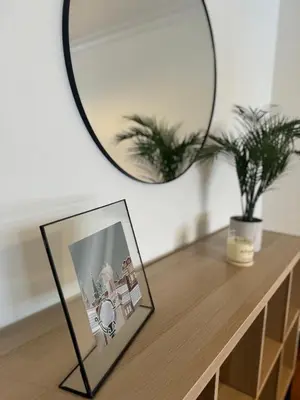 a mirror on top of a wooden table with a picture at As Travesas II in Betanzos