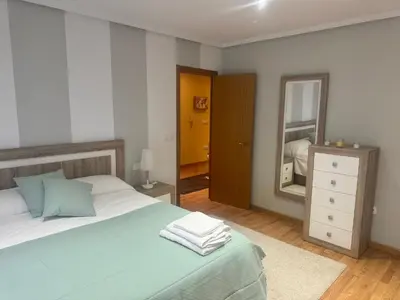 a bedroom with a large bed and a mirror at El rincón de Emilio in Monforte de Lemos