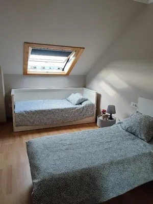 a bedroom with two beds and a window at Apartamento Atico Lúa As Catedrais in San Miguel de Reinante