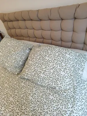 a bed with a black and white comforter and pillows at Apartamento Atico Lúa As Catedrais in San Miguel de Reinante