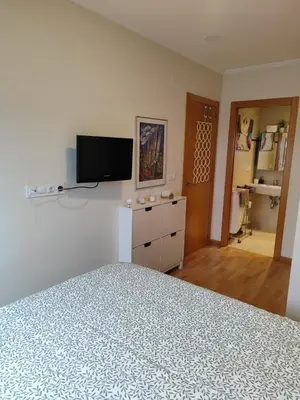 a bedroom with a bed and a flat screen tv at Apartamento Atico Lúa As Catedrais in San Miguel de Reinante