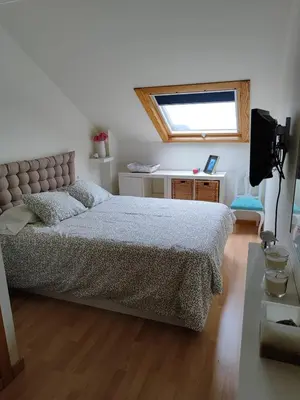 a bedroom with a bed and a television in it at Apartamento Atico Lúa As Catedrais in San Miguel de Reinante