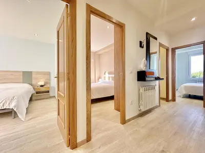 a bedroom with two beds and a mirror at Sea Horizon I in Sada