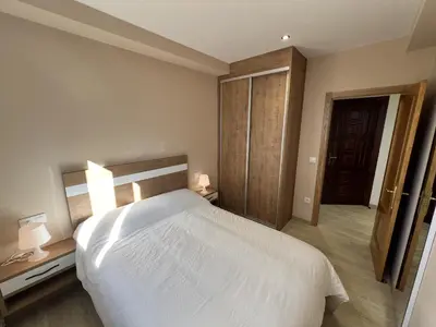 a bedroom with a large white bed and two lamps at Sea Horizon I in Sada