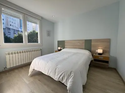 a bedroom with a large bed and two windows at Sea Horizon I in Sada